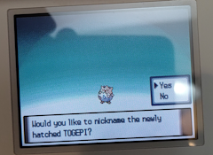 A togepi, the text on the bottom reads 'Would you like to nickname the newly hatched togepi?'. There is a yes or no selector above the right of the bottom text, currently selected is the 'yes' option.