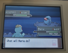 A battle, on the left is a machamp; her name is 'Marie', on the right is a nosepass.
